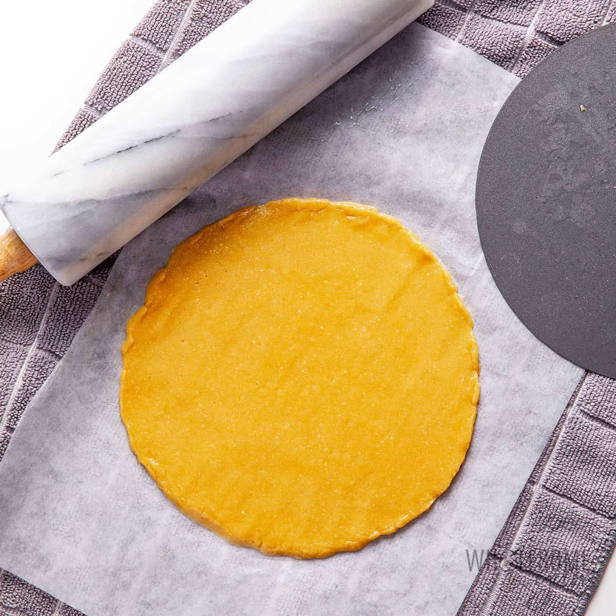 Dough rolled out into a cake layer with a rolling pin.