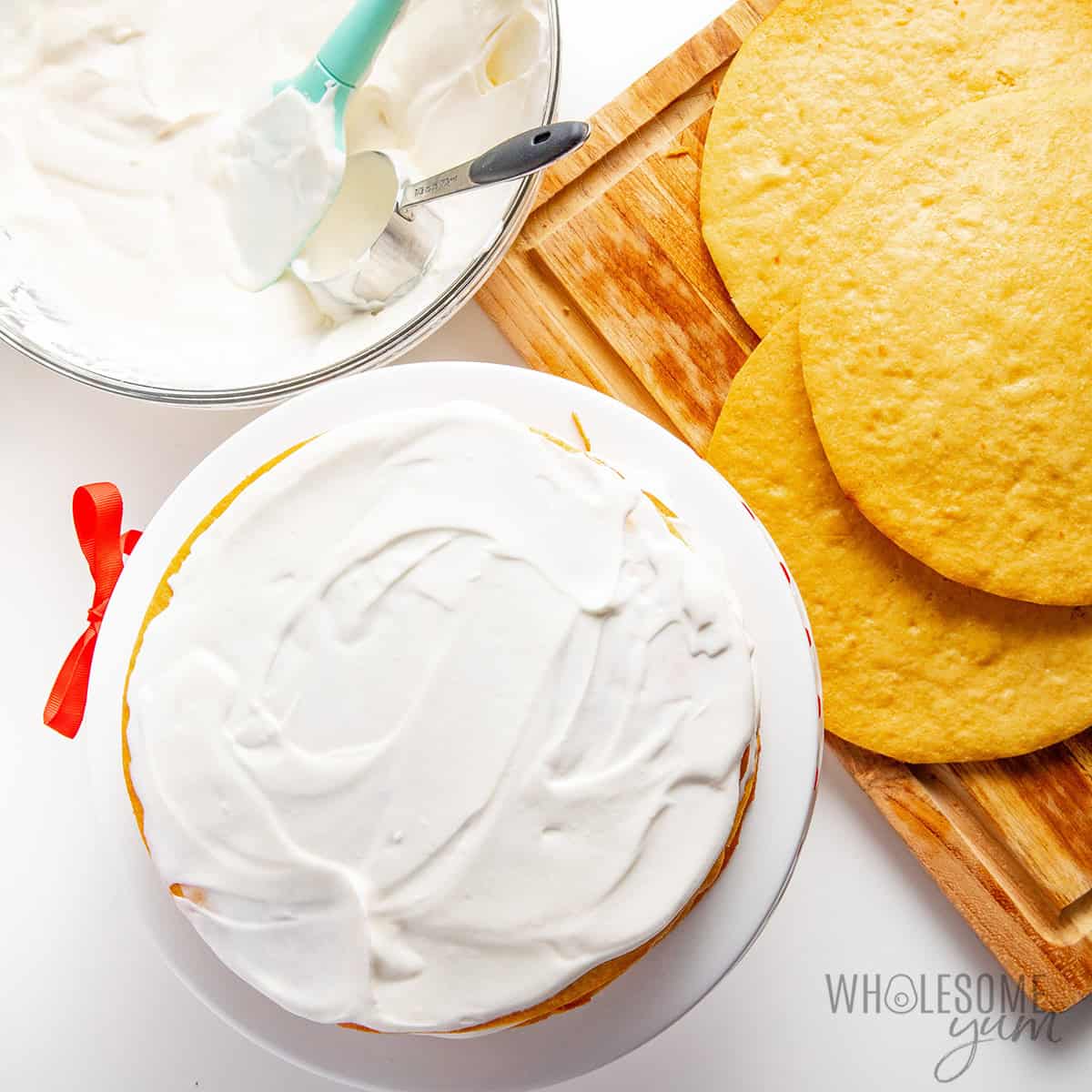 Assembling the Russian honey cake with frosting and cake layers.