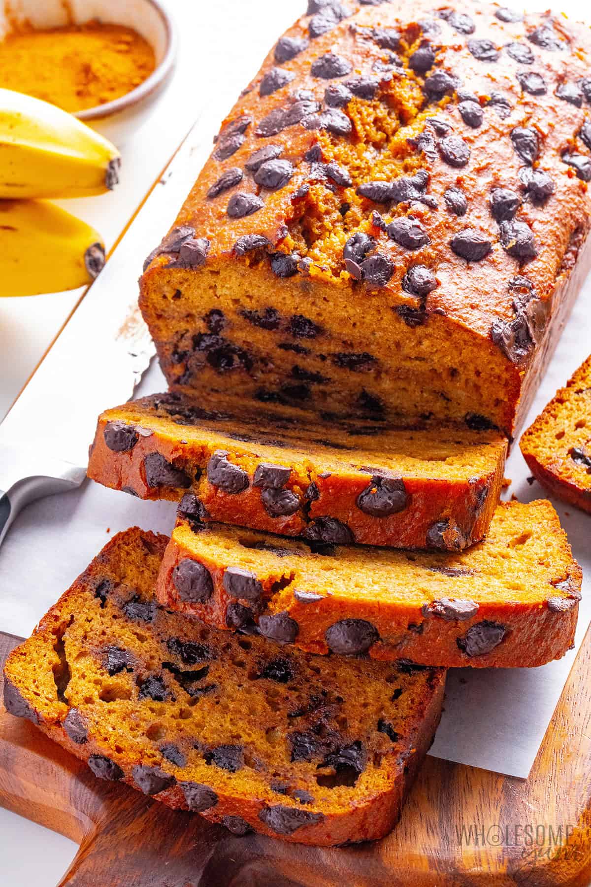 Soft, moist pumpkin banana bread sliced on a cutting board.